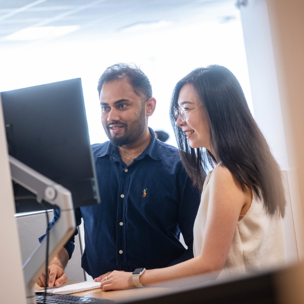 Two individuals working together at a computer.