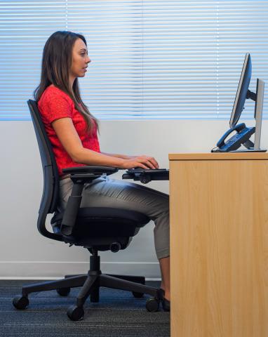 women sitting in ergonomic position at computer desk
