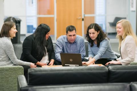 Five people looking at a laptop