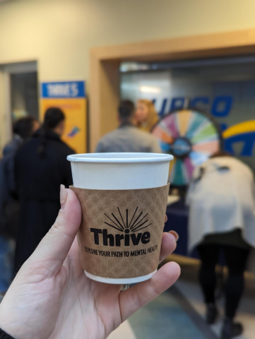 Coffee cup with Thrive sleeve