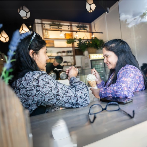 Two individuals sitting and having ice cream.