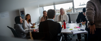 Staff members seated at a table in a workshop