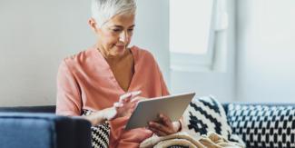 Lady, sitting on a couch using an tablet device