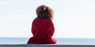 Person looking off to the horizon, wearing a red jacket