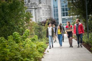 A group of four people walking together outdoors.