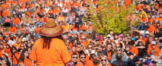 Dana-Lyn Mackenzie speaking to hundreds of attendees at UBC for the Orange Shirt Day intergenerational march. (Photo credit: Oliver Mann)