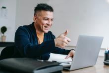 person giving thumbs up to laptop screen