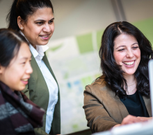 Three smiling women in an office setting
